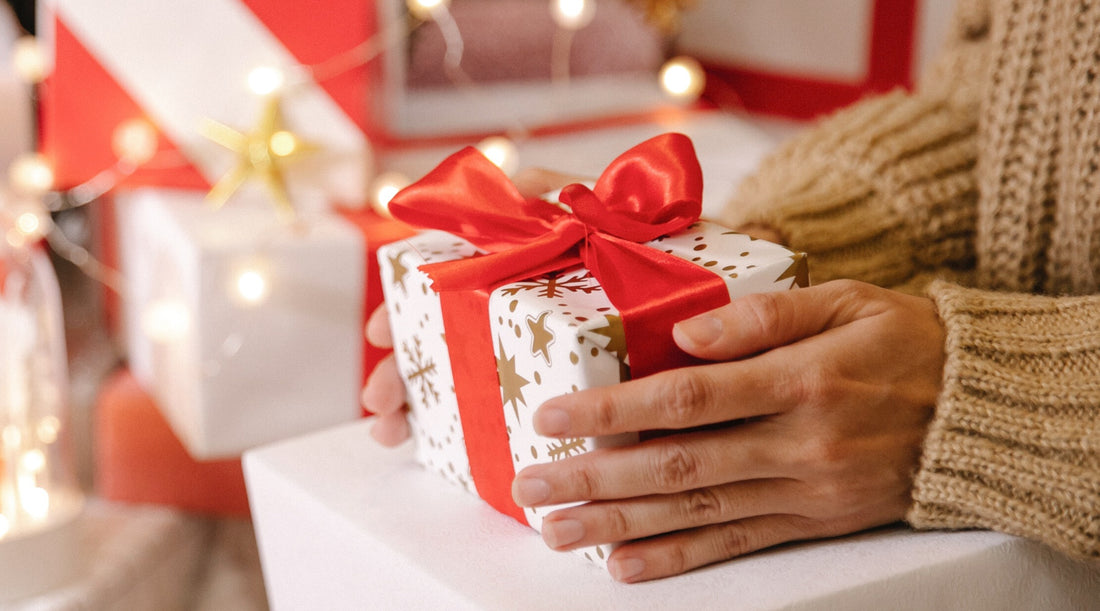 woman holding a wrapped Christmas gift with big red bow