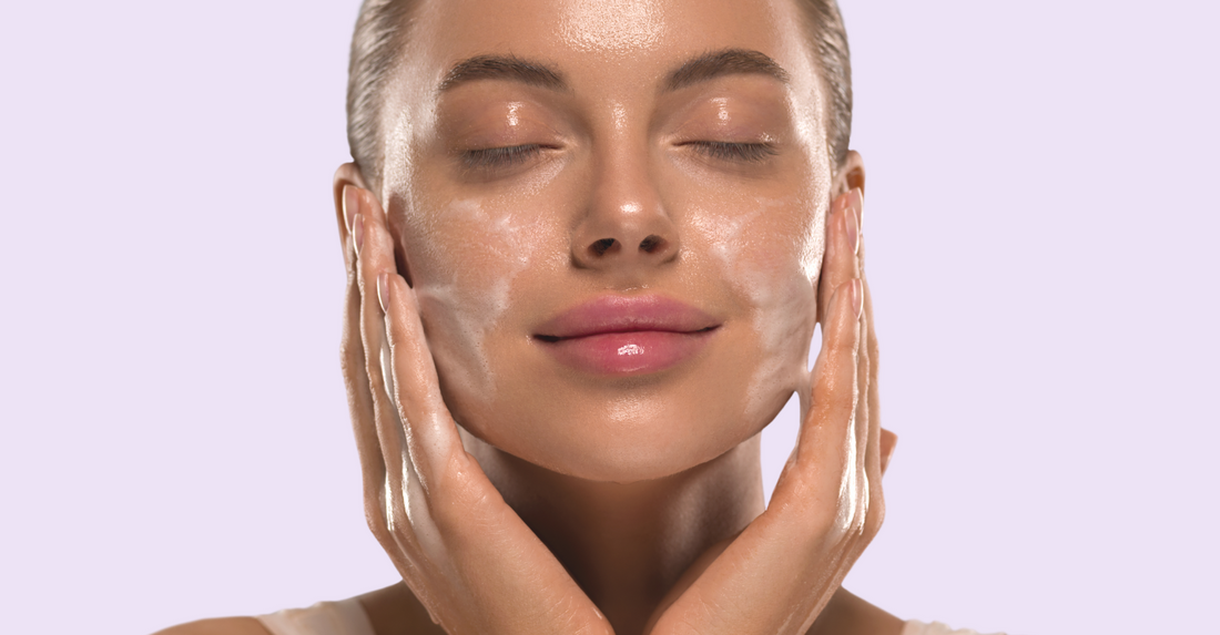 A woman cleansing her skin. Her skin is glowing and she is smiling.
